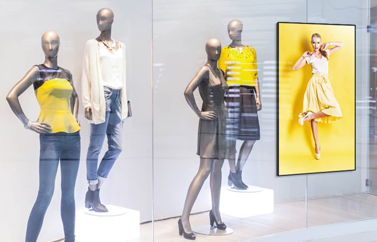 écran dans une vitrine entouré de mannequins